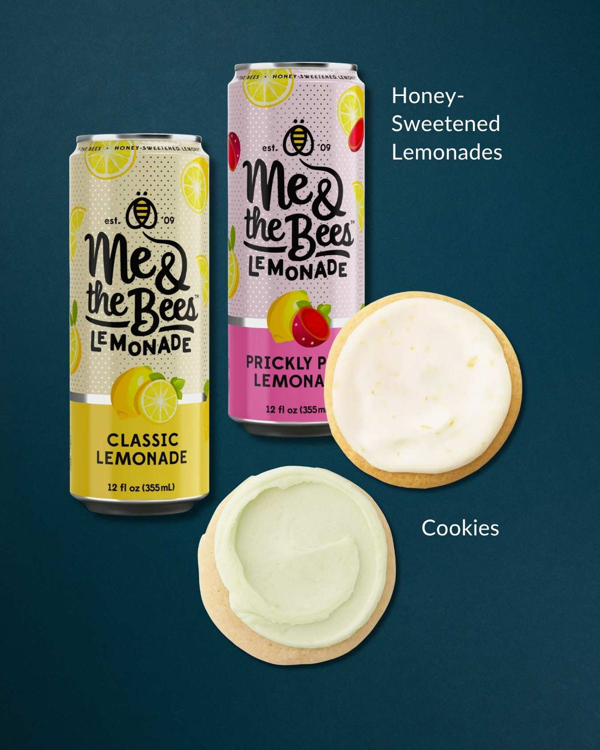 Two Me & the Bees honey-sweetened lemonade cans in classic and prickly pear flavors with two frosted citrus cookies.