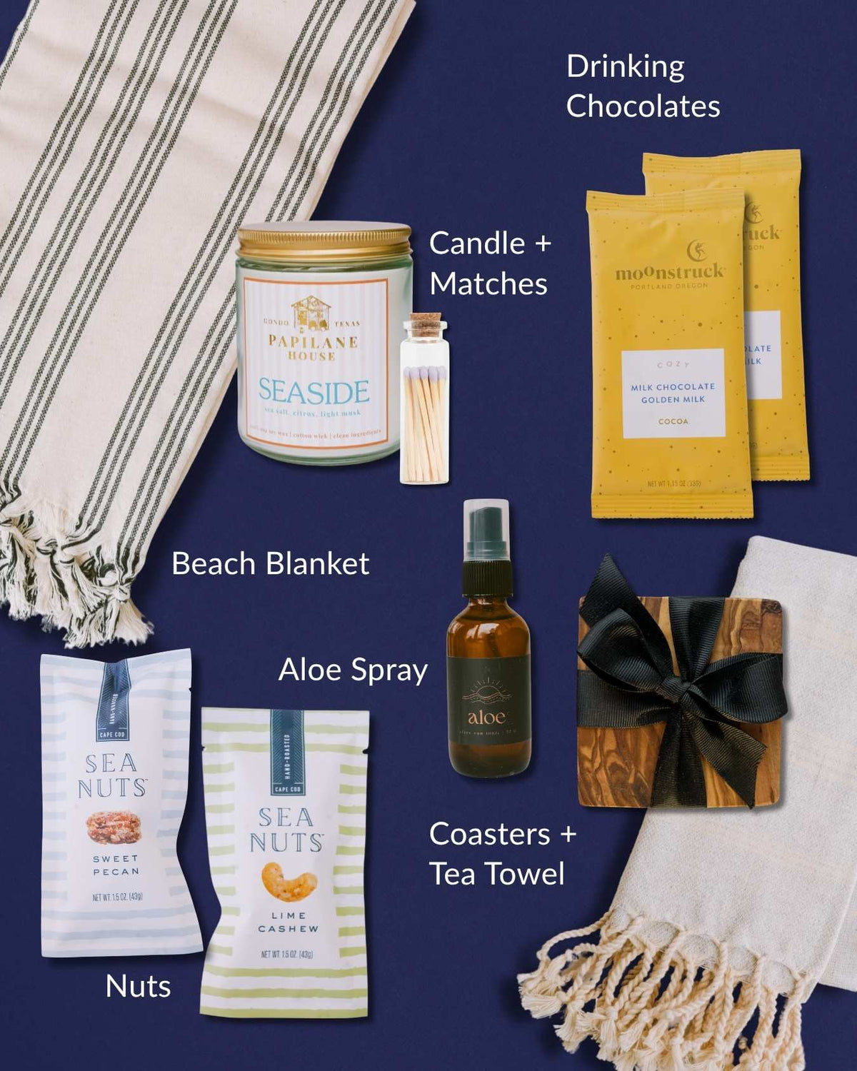 Coastal gift set featuring a Turkish blanket, olive wood coasters, seaside candle, aloe spray, drinking chocolate, and snacks.