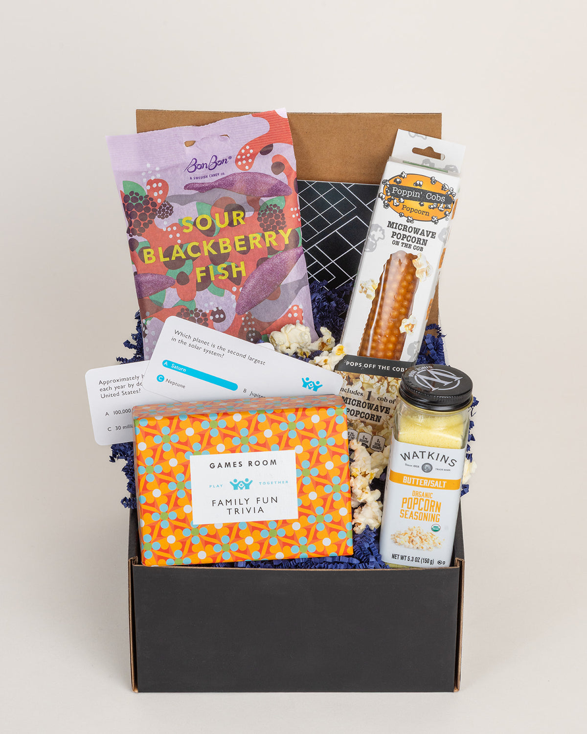Family Fun Night gift box with trivia game, Swedish blackberry fish candy, popcorn on the cob, and organic butter salt seasoning.
