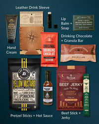 Rugged gift box set featuring leather koozie, beef jerky, hot sauce, hand cream, soap, snacks, and drinking chocolate on dark background.