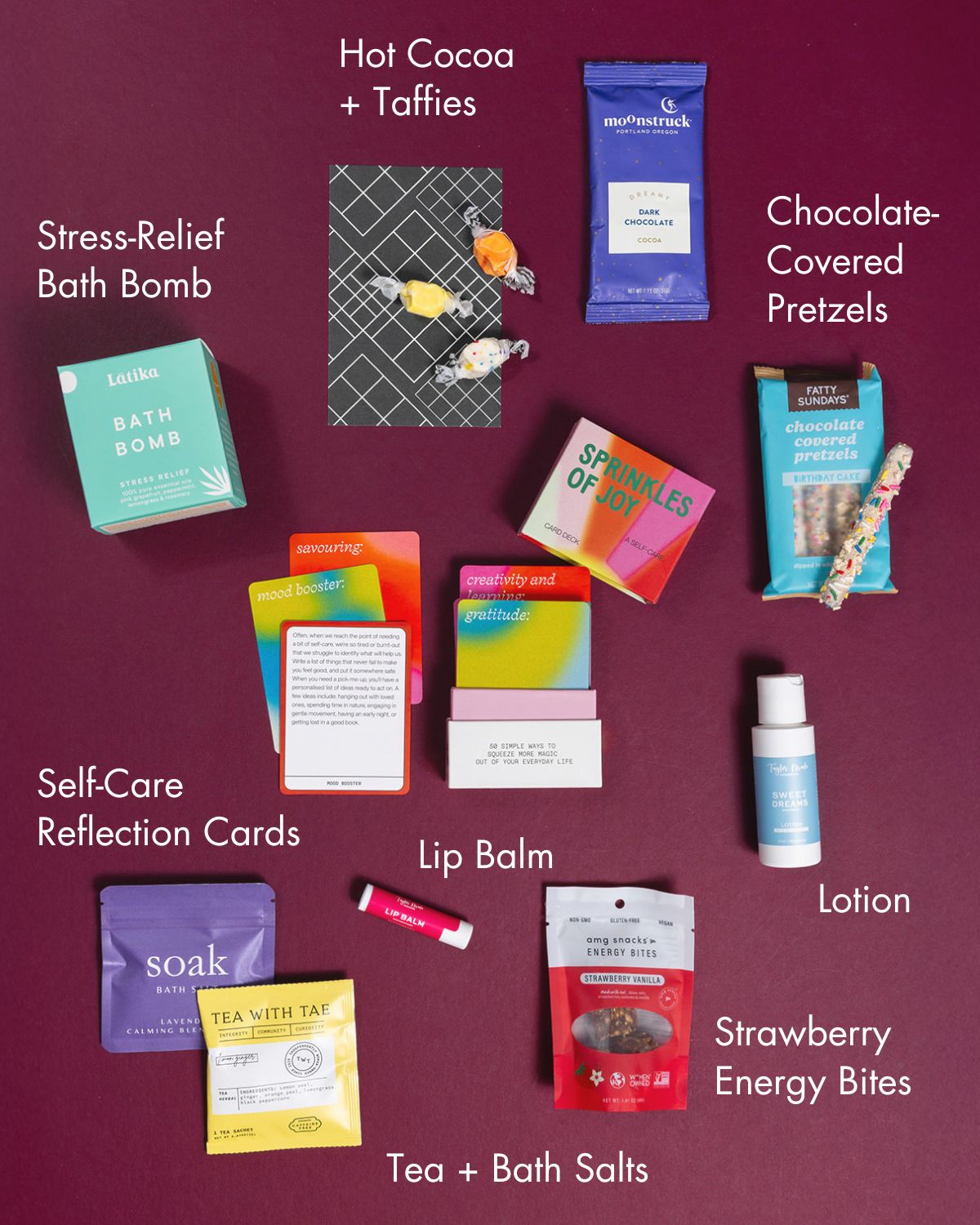 Happy Box gift set featuring colorful self-care items, bath products, snacks, and reflection cards on a deep purple background.