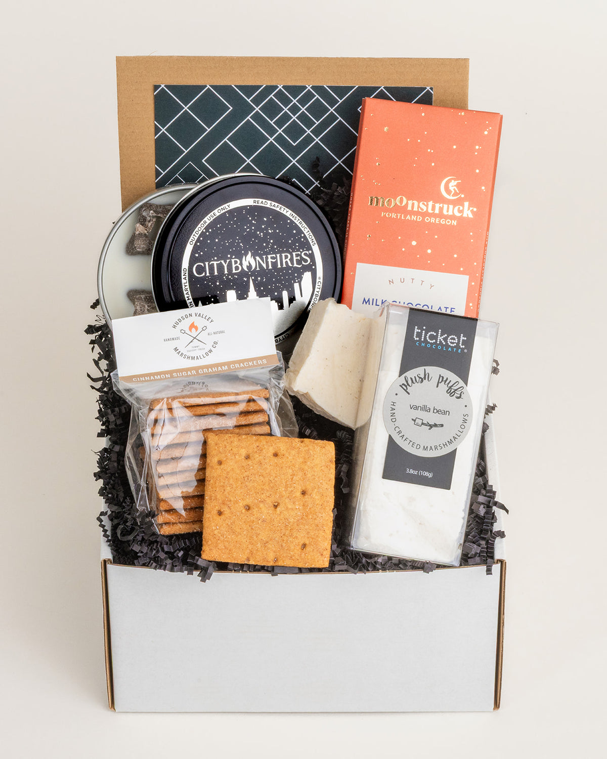 Mini s'mores gift box with a City Bonfires mini fire pit, Moonstruck chocolate, vanilla marshmallows, and graham crackers.