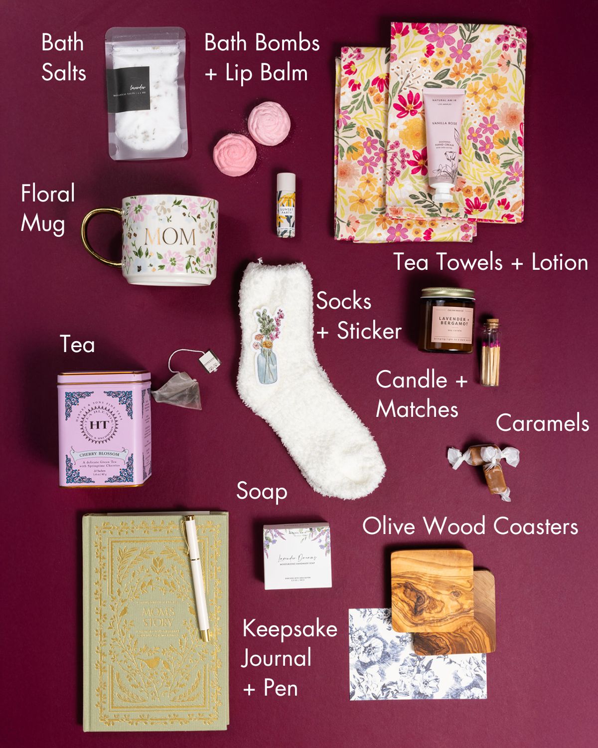 Mom’s Heirloom Gift set featuring a floral mug, keepsake journal, cozy white socks, tea, bath salts, and spa essentials on burgundy.