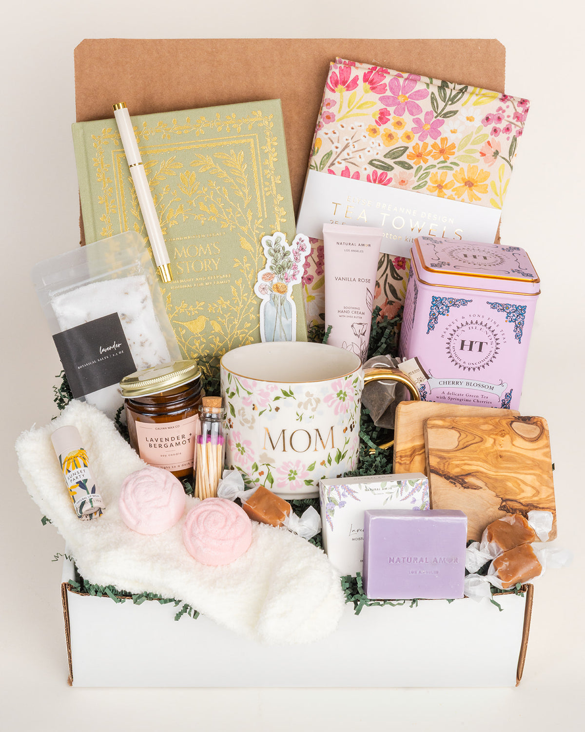 Mom’s Heirloom gift box featuring a floral mug, sage green journal, tea towels, bath salts, candle, and self-care essentials.