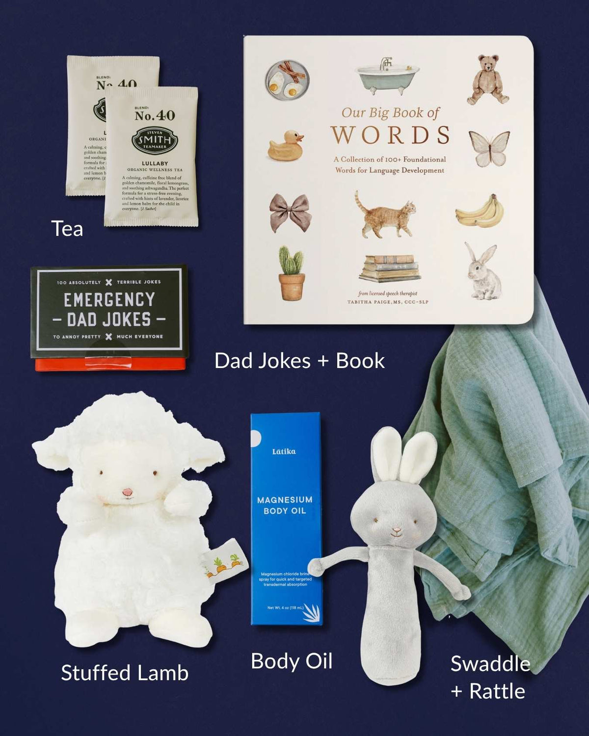 New baby gift box with board book, Emergency Dad Jokes, tea, magnesium oil, plush lamb, bunny rattle, and green swaddle.