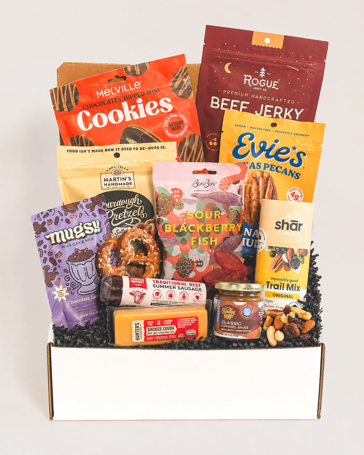 Snack Attack gift box filled with assorted jerky, sourdough pretzels, smoked gouda, caramel sauce, cookies, and trail mix.