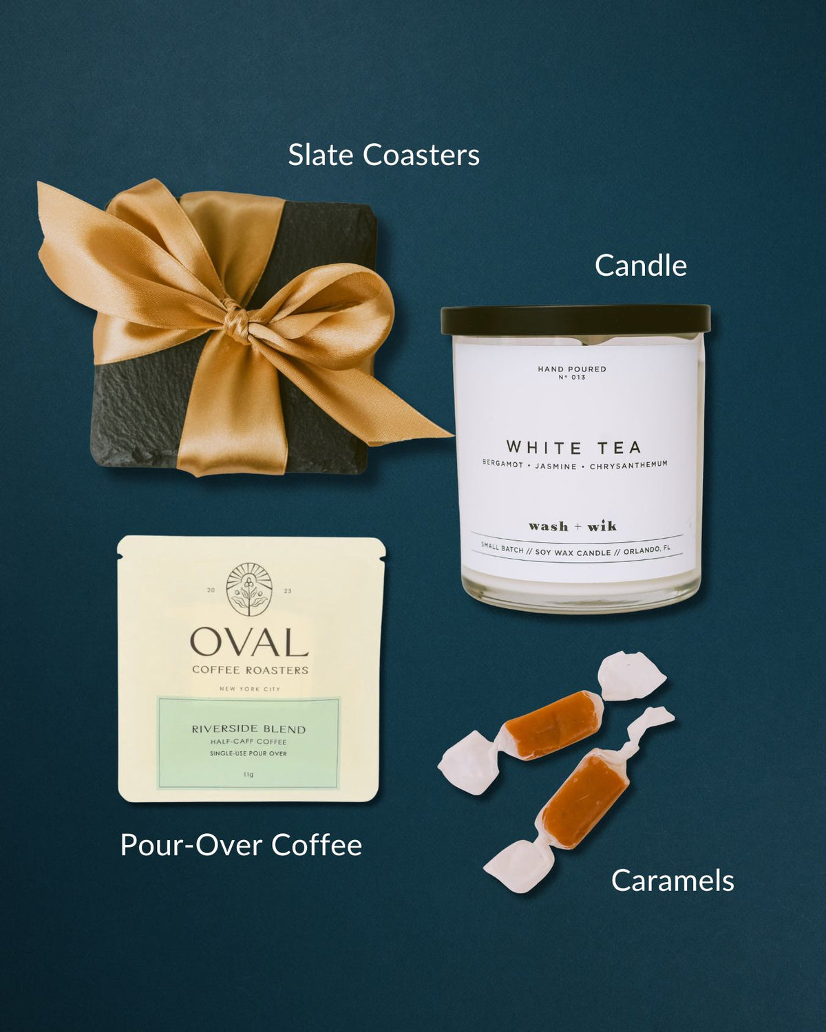 The Classic Home gift set with slate coasters, white tea candle, pour-over coffee, and caramels on a dark blue background.