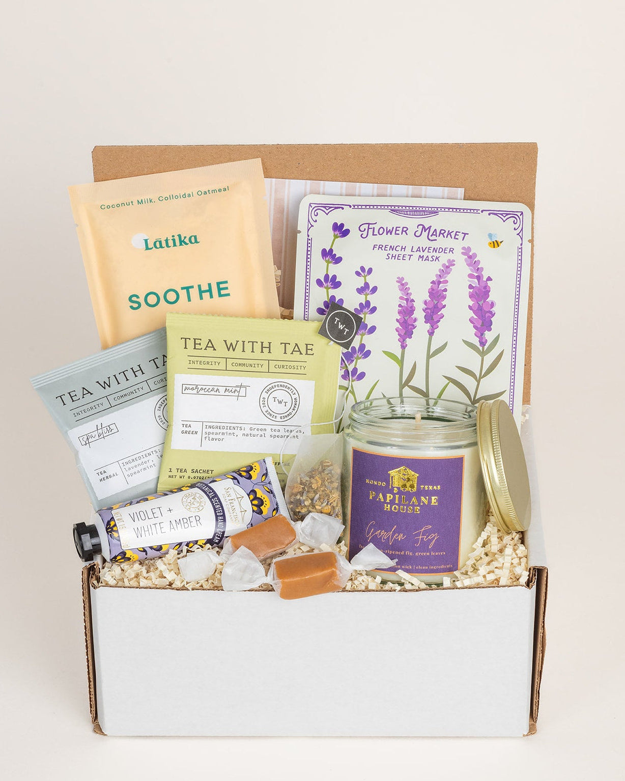 Gift box with tea, lavender products, and a candle on a white background