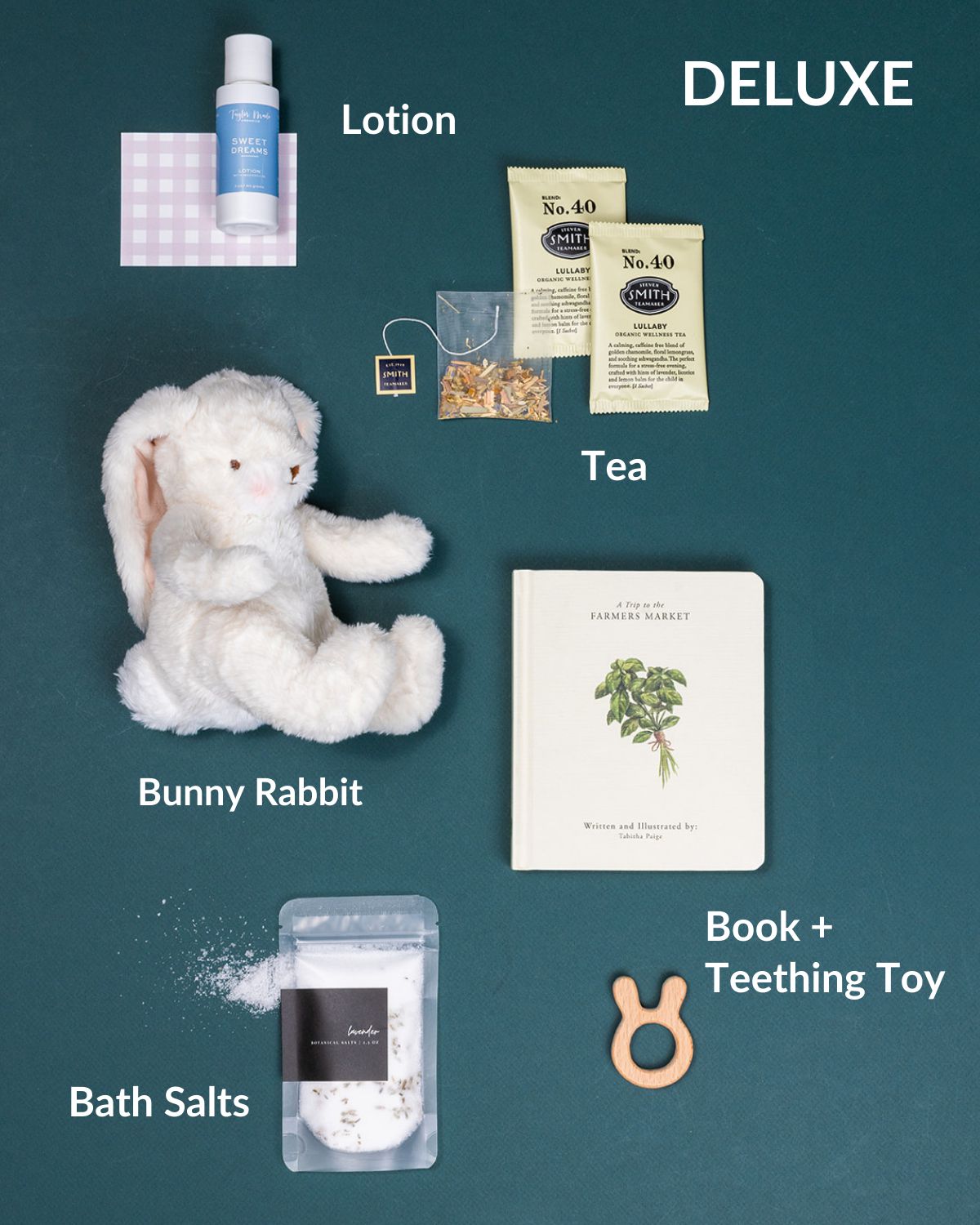 Welcome, Baby deluxe gift set featuring lotion, tea, bath salts, bunny rabbit, book, and teething toy.