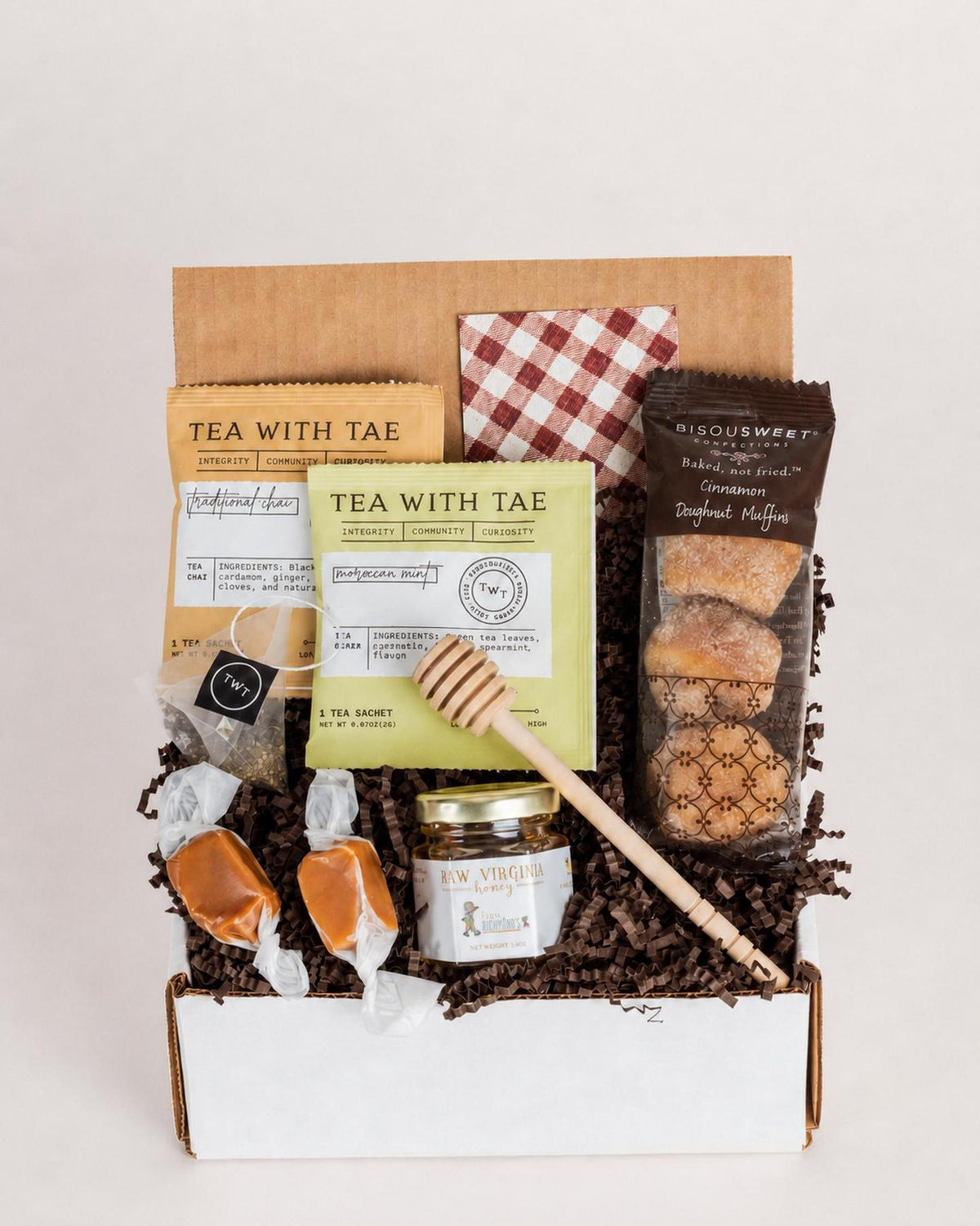 Autumn gift box with doughnut muffins, two tea bags, raw honey with a wooden dipper, and two sea salt caramels.