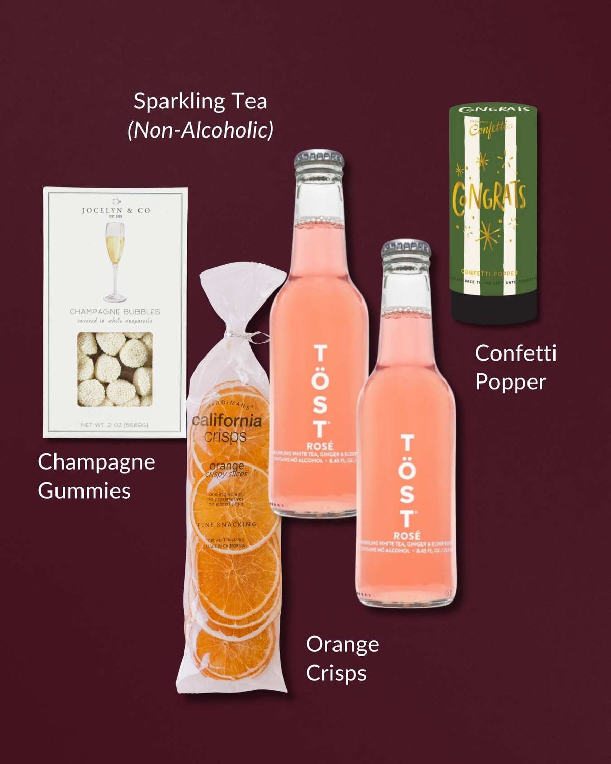 Non-alcoholic gift set with two bottles of pink sparkling rosé, orange citrus crisps, champagne gummies, and a confetti popper.