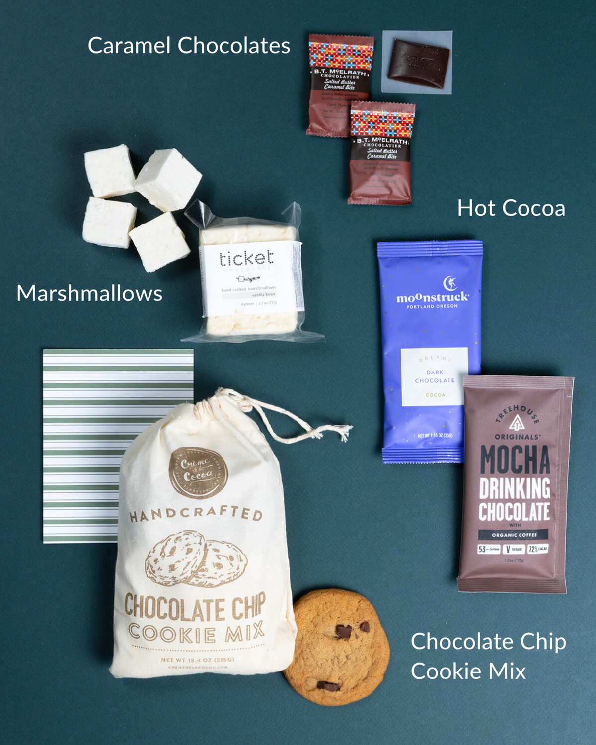Cookie kit with chocolate chip mix bag, vanilla marshmallows, drinking chocolate, caramel bites, and a striped note card.