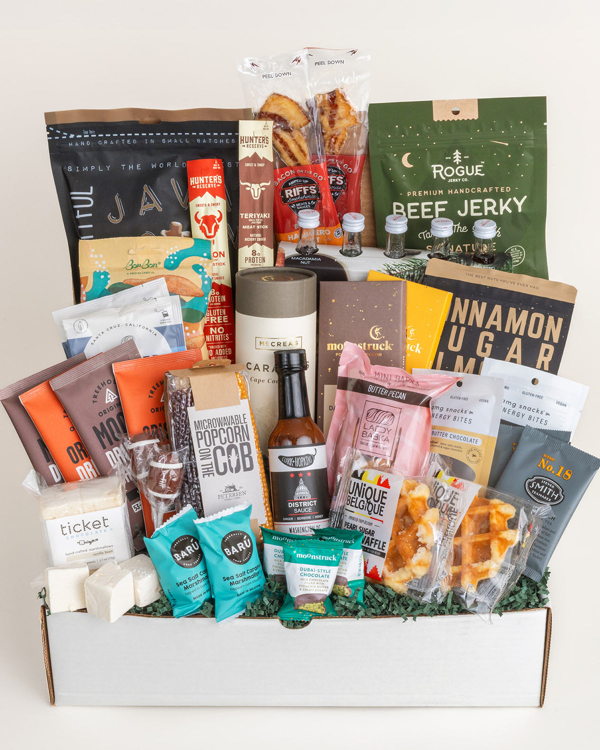 Large gift box filled with premium snacks including beef jerky, popcorn on the cob, chocolates, hot sauce, and gourmet treats.