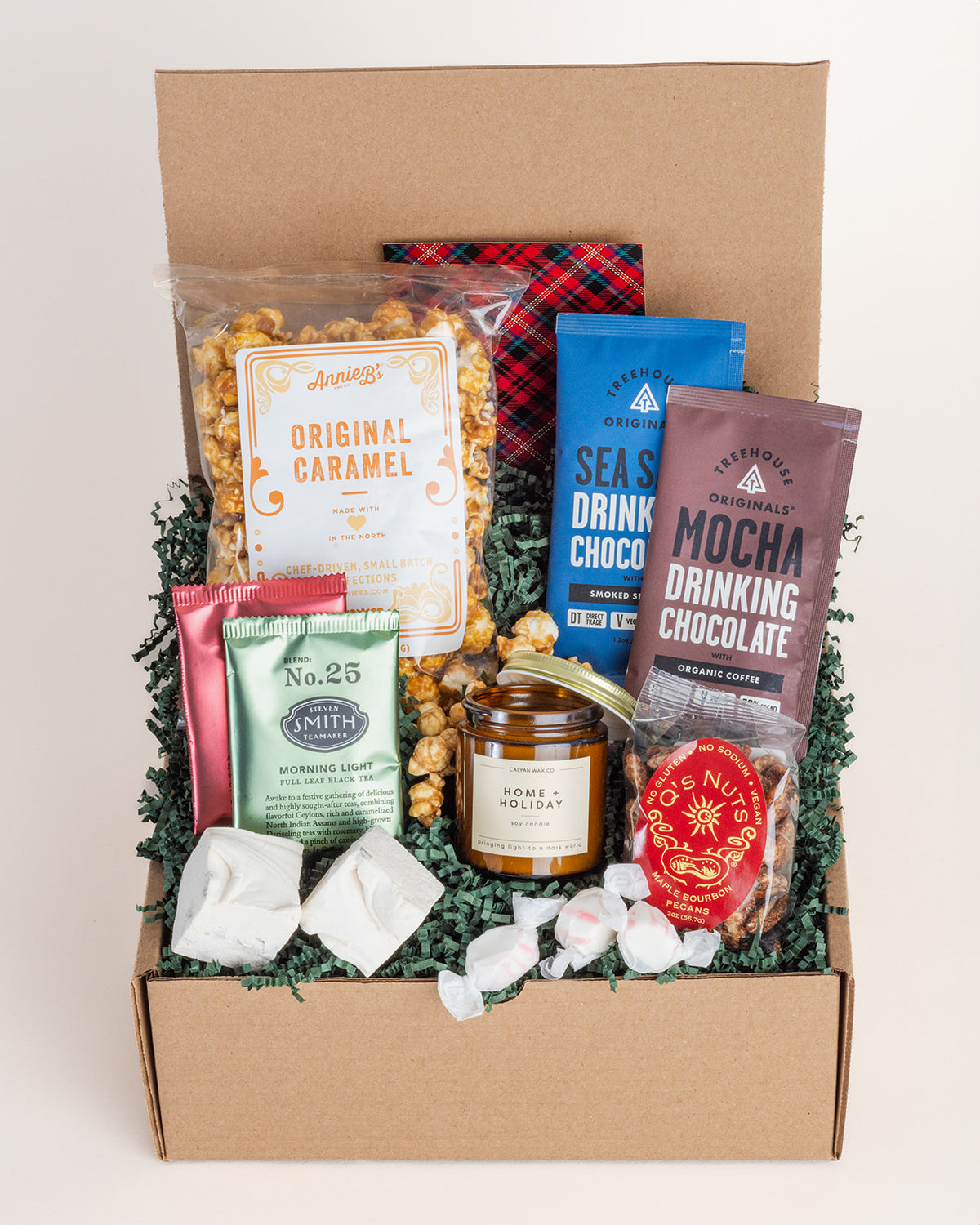 Holiday gift box filled with caramel popcorn, drinking chocolates, tea, candied pecans, marshmallows, and a soy candle.