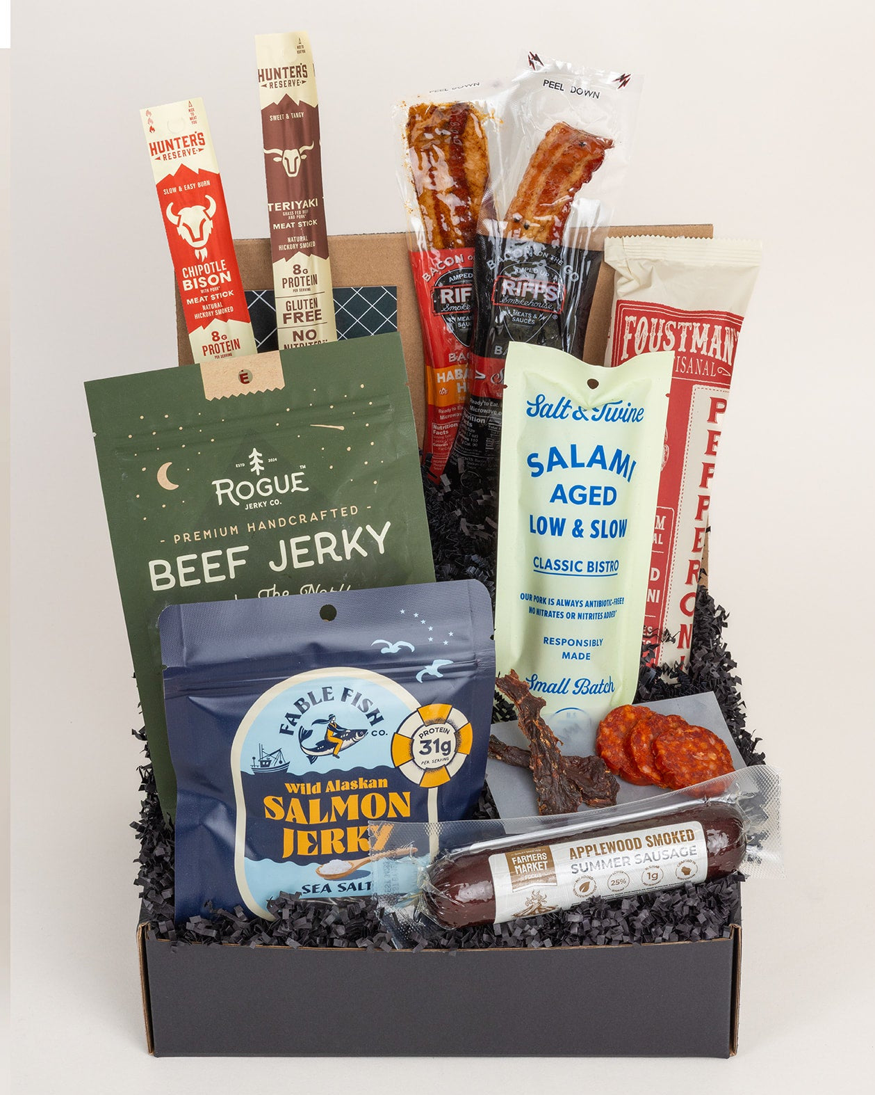 Assorted jerky and snack package with visible brands on a white background