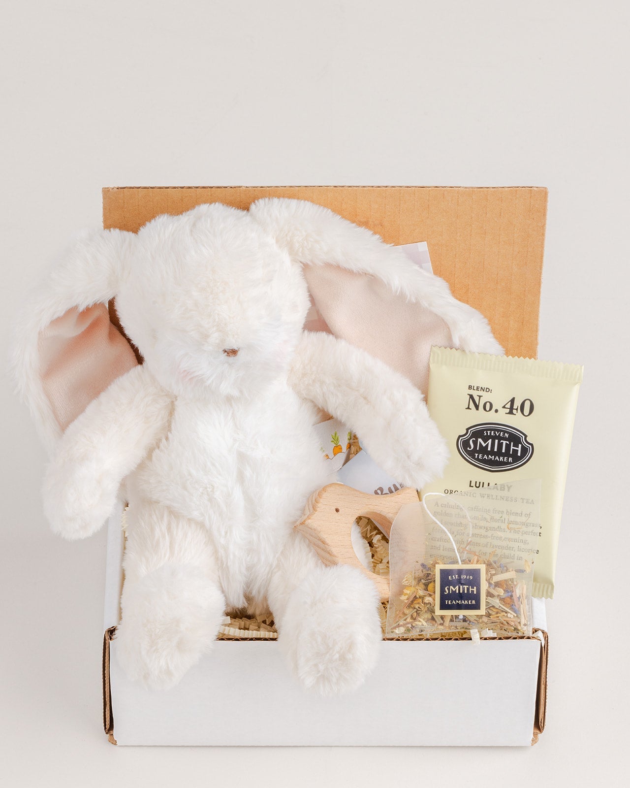 Welcome, Baby gift box with plush bunny, tea, and wooden toy, perfect for new arrivals this Christmas.